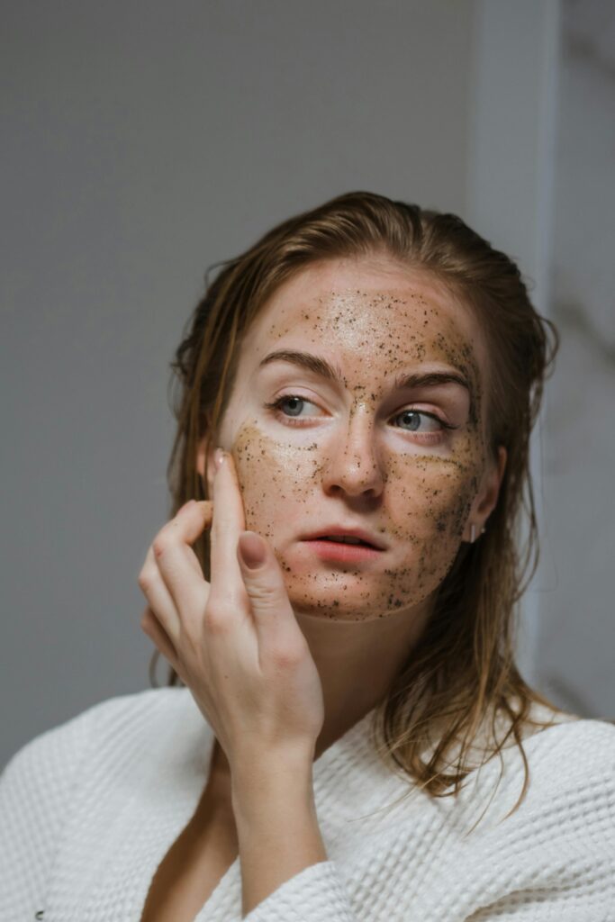 Woman applying a natural exfoliating face mask during her skincare routine, showcasing skincare products and treatments for skin