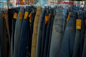 Various women's jeans in different washes and styles displayed on a clothing rack, featuring denim trends and flattering jean styles for women.