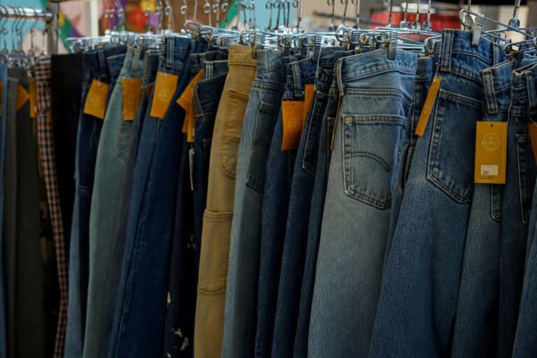 Various women's jeans in different washes and styles displayed on a clothing rack, featuring denim trends and flattering jean styles for women.
