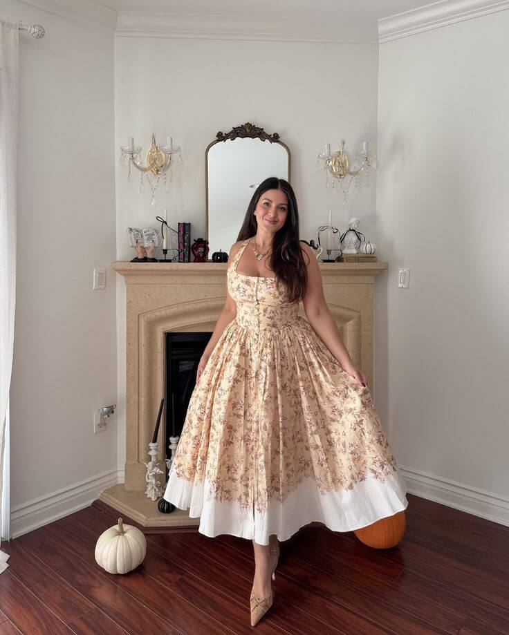 Woman wearing a floral empire waist dress with a fitted bodice and flowing skirt, showing an empire waist dress for a pear-shaped body.