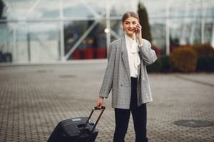 Woman wearing a fall travel outfit while packing for a week with one carry-on suitcase