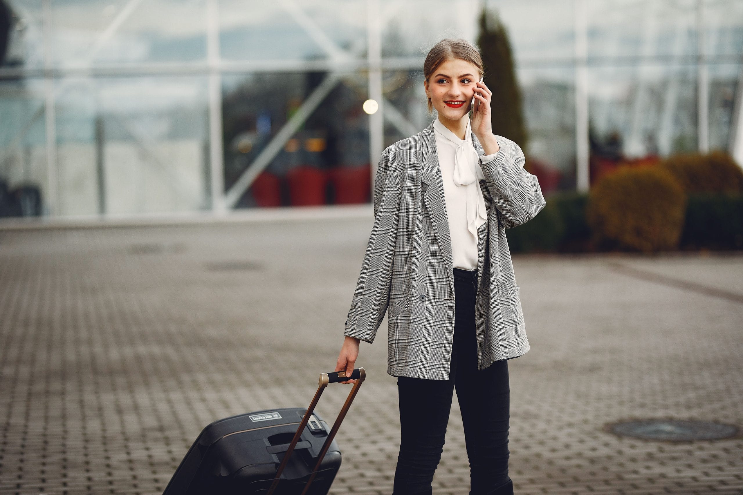 Woman wearing a fall travel outfit while packing for a week with one carry-on suitcase