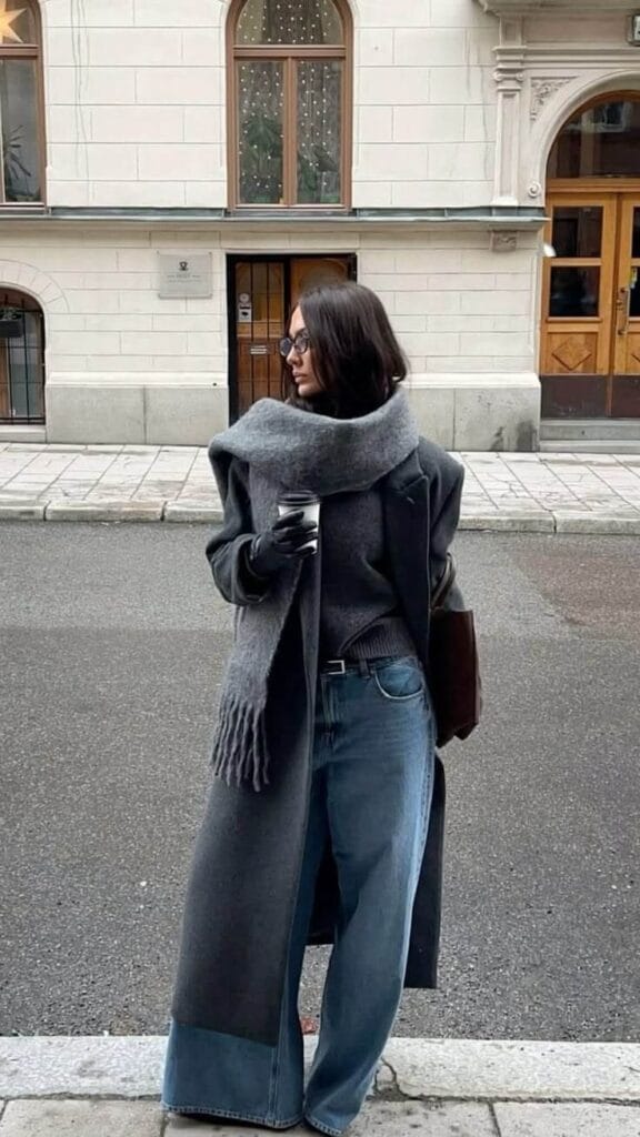 How to style a trench coat with a warm scarf and jeans for a cold fall outfit.