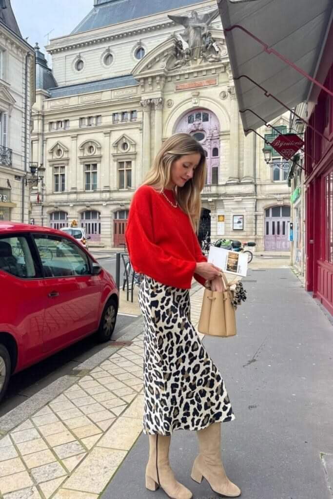 How to style an animal print dress with a cropped red sweater and neutral knee-high boots.