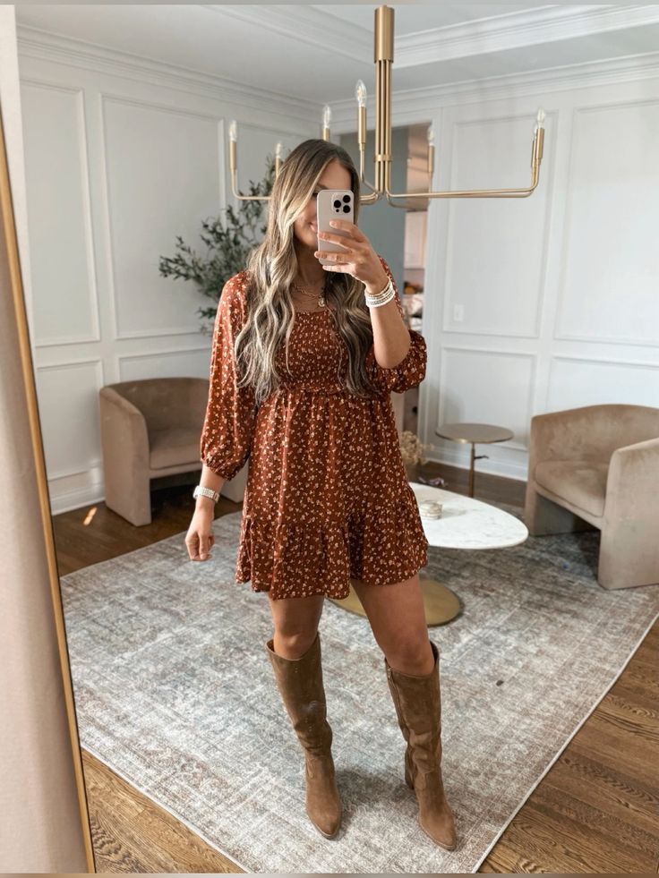 Woman wearing a rust-colored floral wrap-style mini dress with puff sleeves and brown knee-high boots, showcasing a wrap dress outfit for Thanksgiving dinner.
